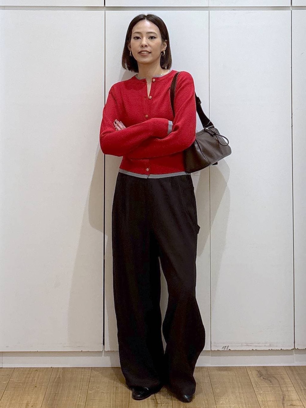 ブラック系のローファー、レッド系のカーディガン/ボレロ、ブラウン系のショルダーバッグを着用したレディースの冬コーディネートの4枚目の写真