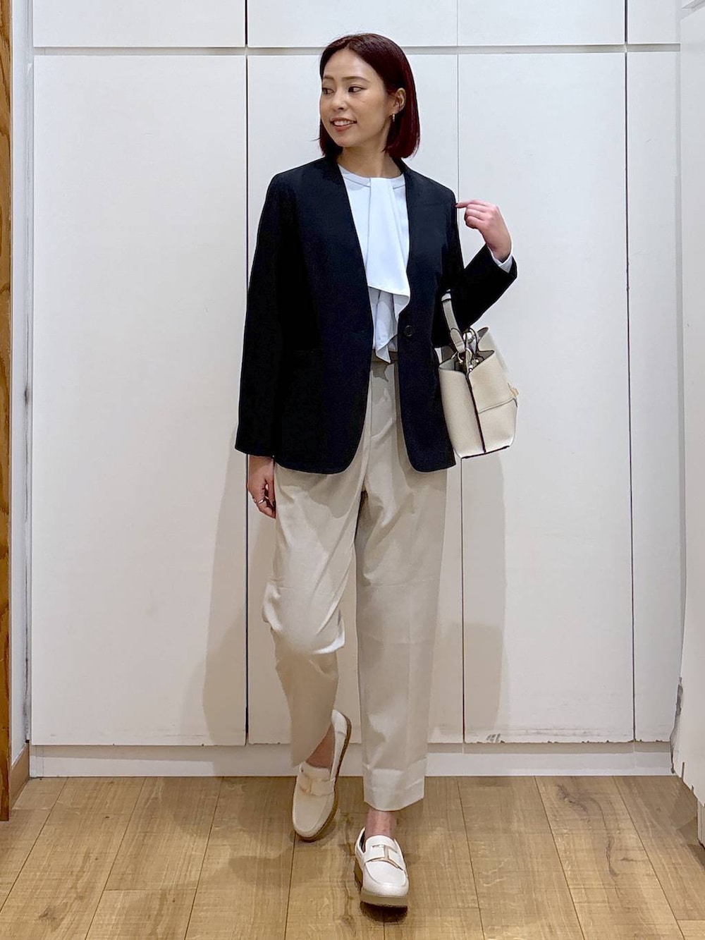 ホワイト系のローファー、ベージュ系のスラックス、ブルー系のシャツ/ブラウスを着用したレディースの春コーディネートの3枚目の写真