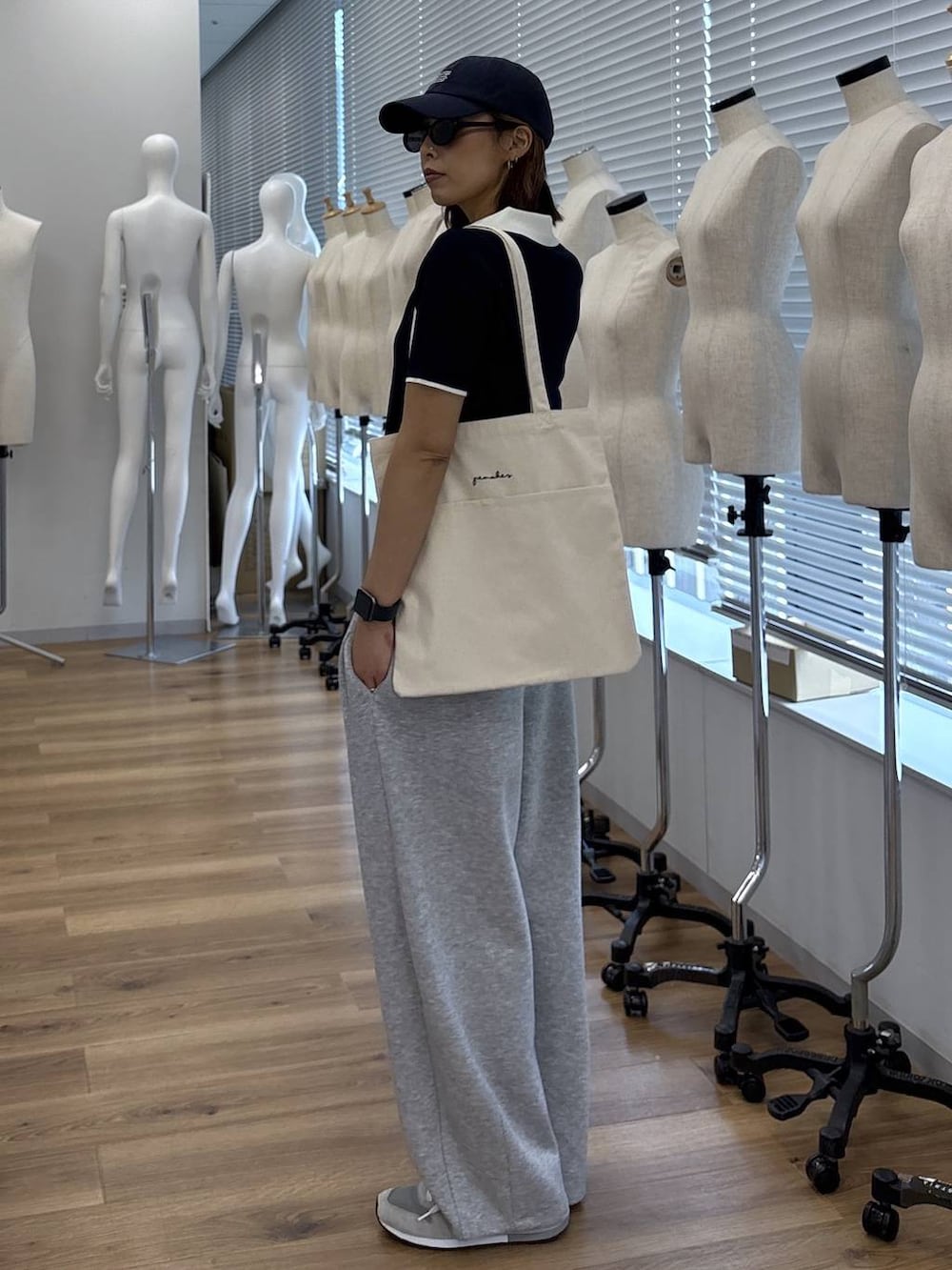 ホワイト系のトートバッグ、グレー系のその他パンツ、ブルー系のニット/セーターを着用したレディースの夏コーディネートの5枚目の写真