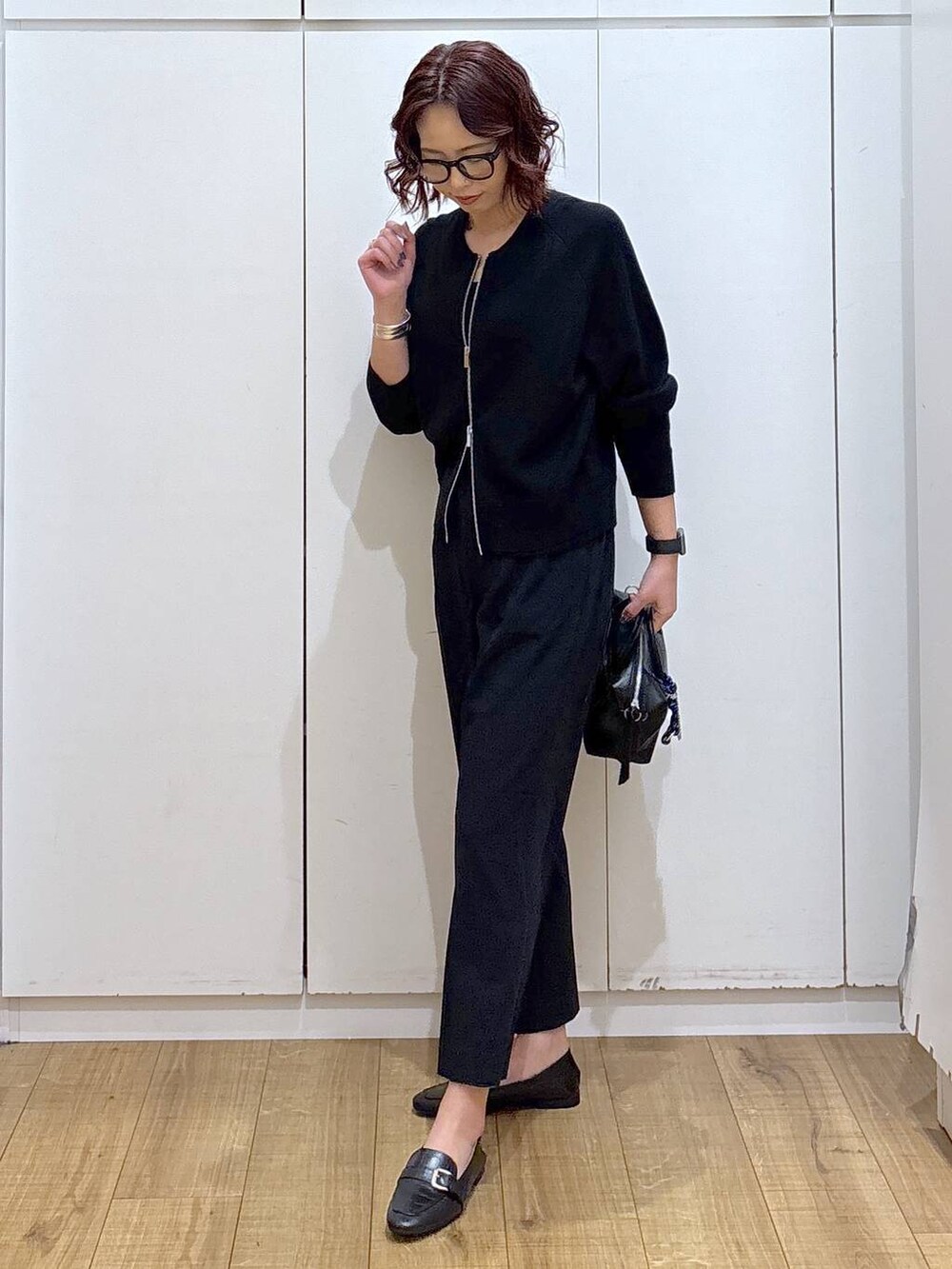 ブラック系のローファー、ブルー系のスラックス、ブラック系のカーディガン/ボレロを着用したレディースの春コーディネートの5枚目の写真