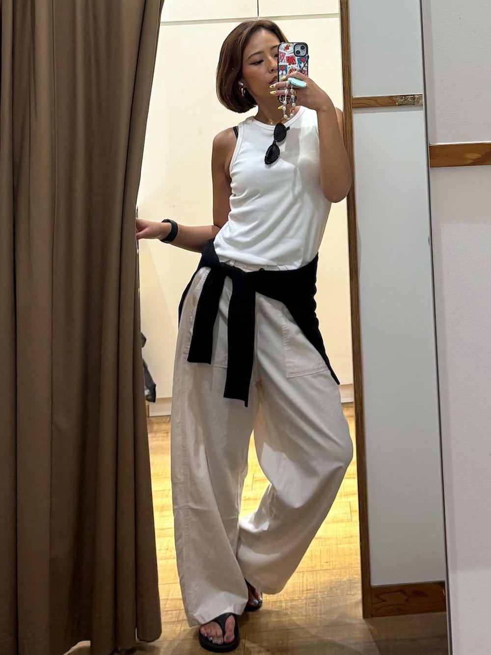 ベージュ系のその他パンツ、ブラック系のカーディガン/ボレロ、ブラック系のサンダルを着用したレディースの夏コーディネートの2枚目の写真