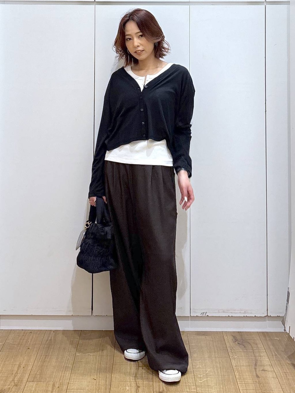 ブラウン系のその他パンツ、ホワイト系のタンクトップ、ブラック系のカーディガン/ボレロを着用したレディースの春コーディネートの2枚目の写真