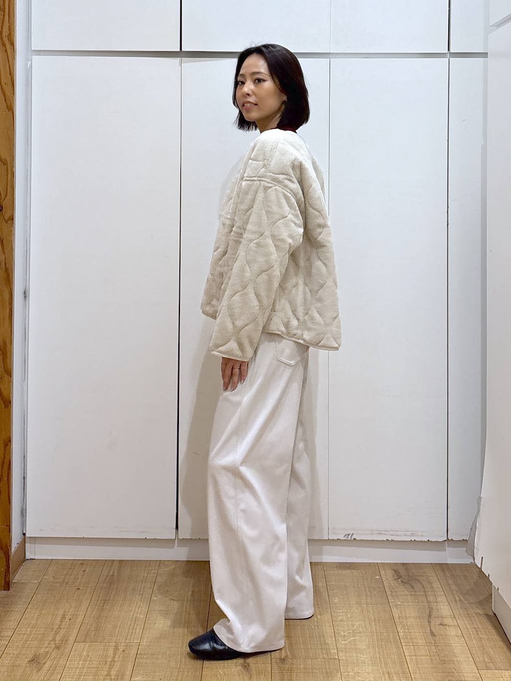 ベージュ系のブルゾン、レッド系のニット/セーター、グレー系のその他パンツを着用したレディースの秋コーディネートの4枚目の写真