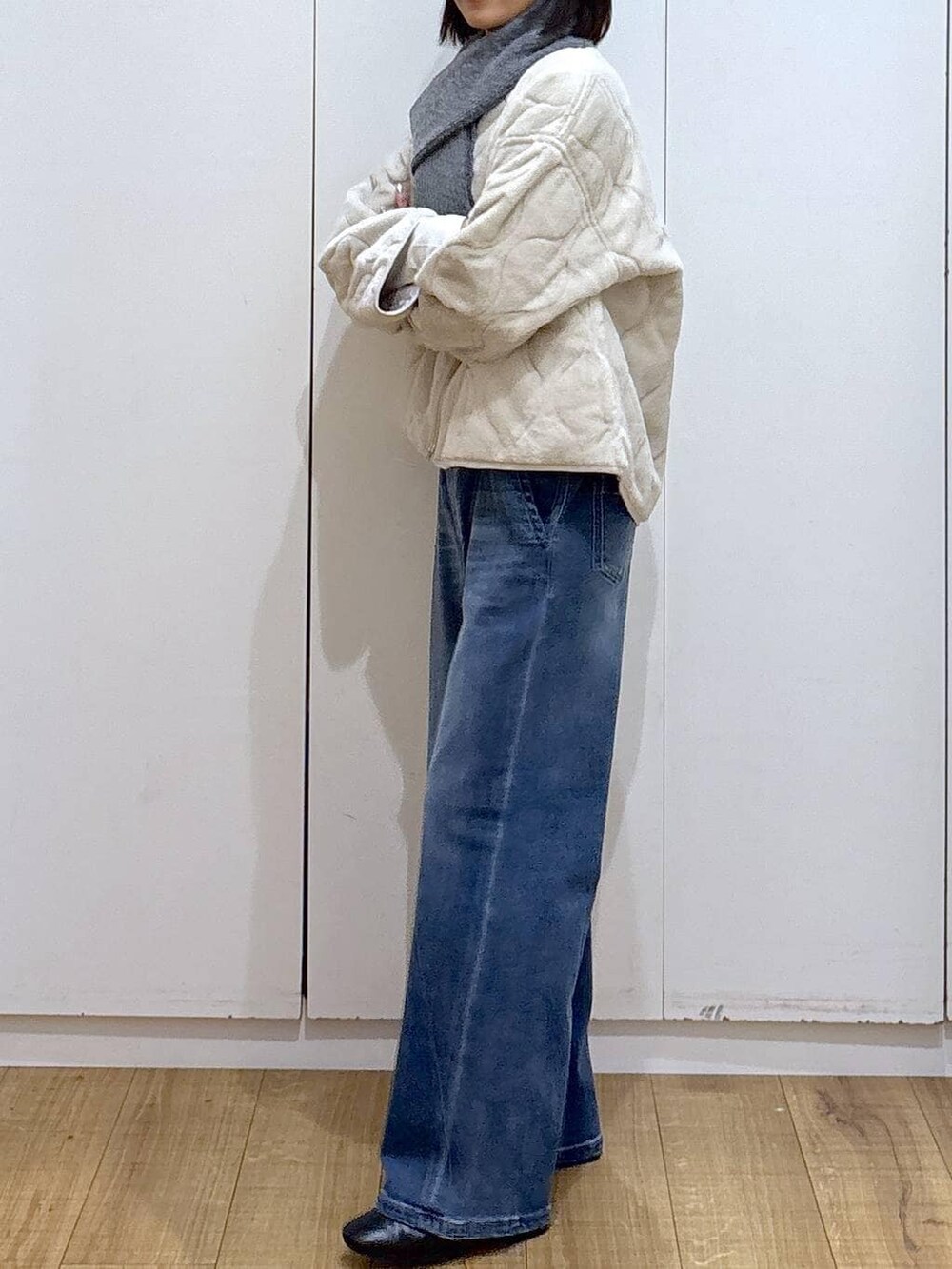 ベージュ系のブルゾン、ブラック系のブーツ、ブルー系のデニムパンツを着用したレディースの秋コーディネートの3枚目の写真