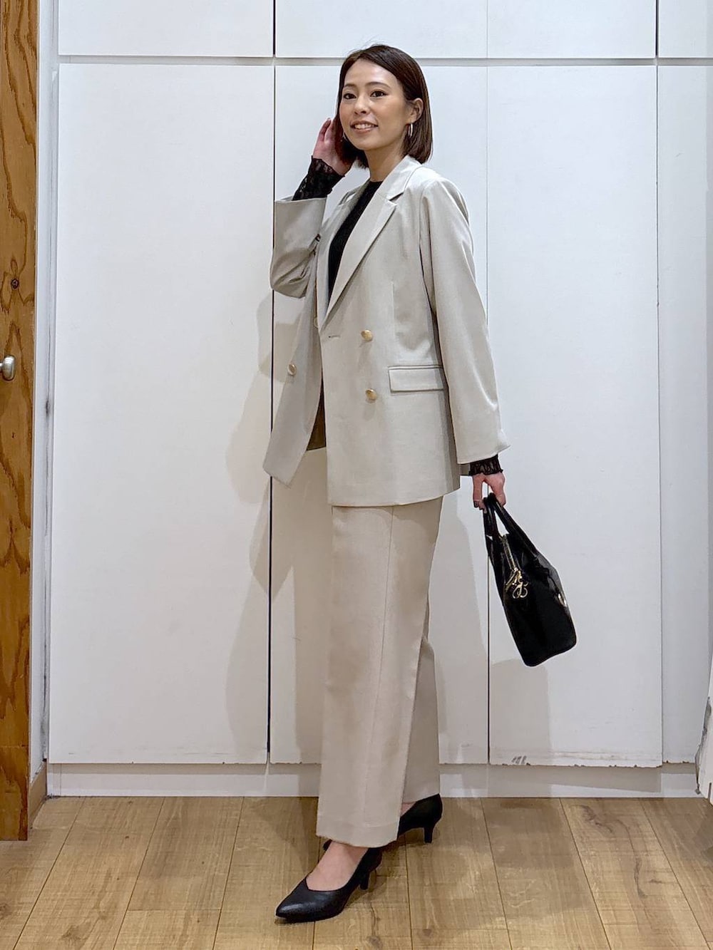 ブラック系のショルダーバッグ、ブラック系のパンプス、ブラック系のTシャツ/カットソーを着用したレディースの冬コーディネートの5枚目の写真