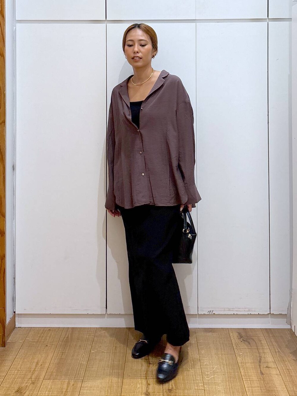 ブラック系のローファー、ブラック系のショルダーバッグ、ブラック系のキャミソールを着用したレディースの秋コーディネートの2枚目の写真