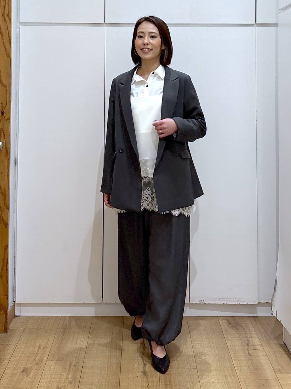 ブラック系のパンプス、ホワイト系のシャツ/ブラウス、グレー系のテーラードジャケットを着用したレディースの冬コーディネートの6枚目の写真
