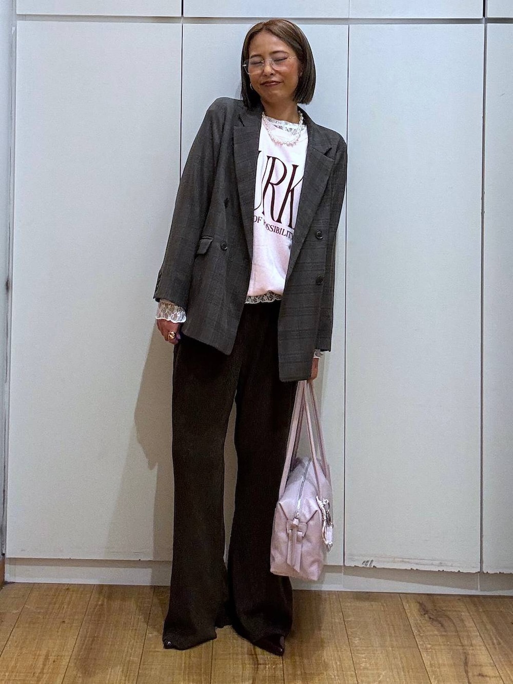 パープル系のボストンバッグ、ホワイト系のTシャツ/カットソー、ブラウン系のテーラードジャケットを着用したレディースの秋コーディネートの5枚目の写真