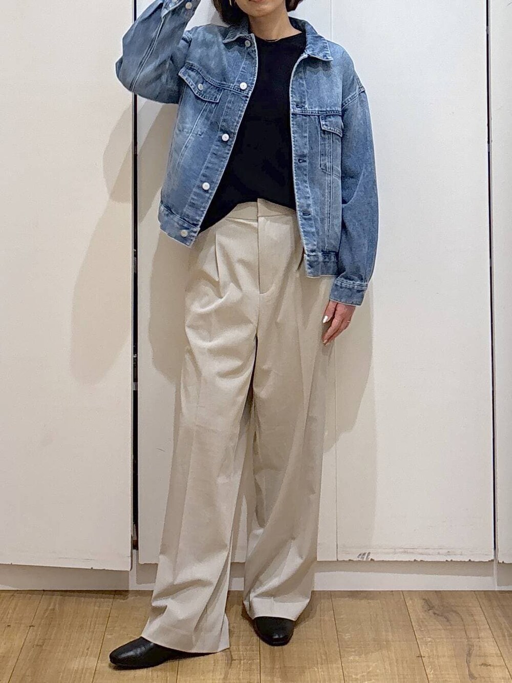 ベージュ系のスラックス、ブラック系のブーツ、ブルー系のデニムジャケットを着用したレディースの冬コーディネートの2枚目の写真