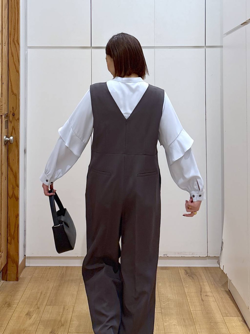 ブラック系のローファー、グレー系のセットアップ、ブラック系のハンドバッグを着用したレディースの冬コーディネートの8枚目の写真