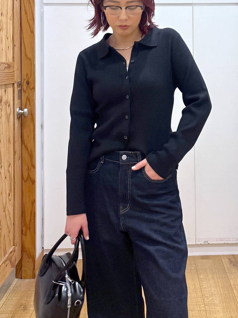 ブルー系のデニムパンツ、ブラック系のボストンバッグ、ブラック系のカーディガン/ボレロを着用したレディースの春コーディネートの7枚目の写真