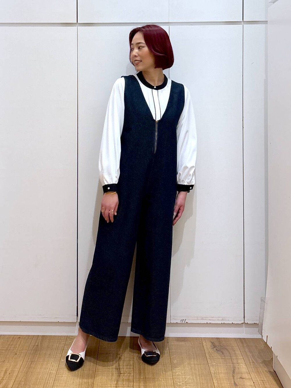 ホワイト系のシャツ/ブラウス、ブルー系のサロペット/オーバーオール、ホワイト系のパンプスを着用したレディースの春コーディネートの2枚目の写真