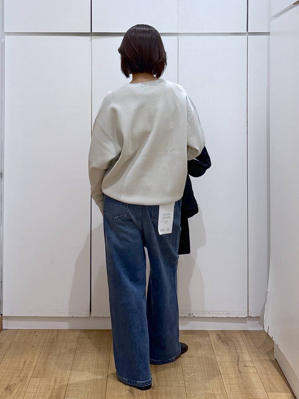 ブルー系のチェスターコート、ベージュ系のスウェット、ブラック系のブーツを着用したレディースの秋コーディネートの7枚目の写真