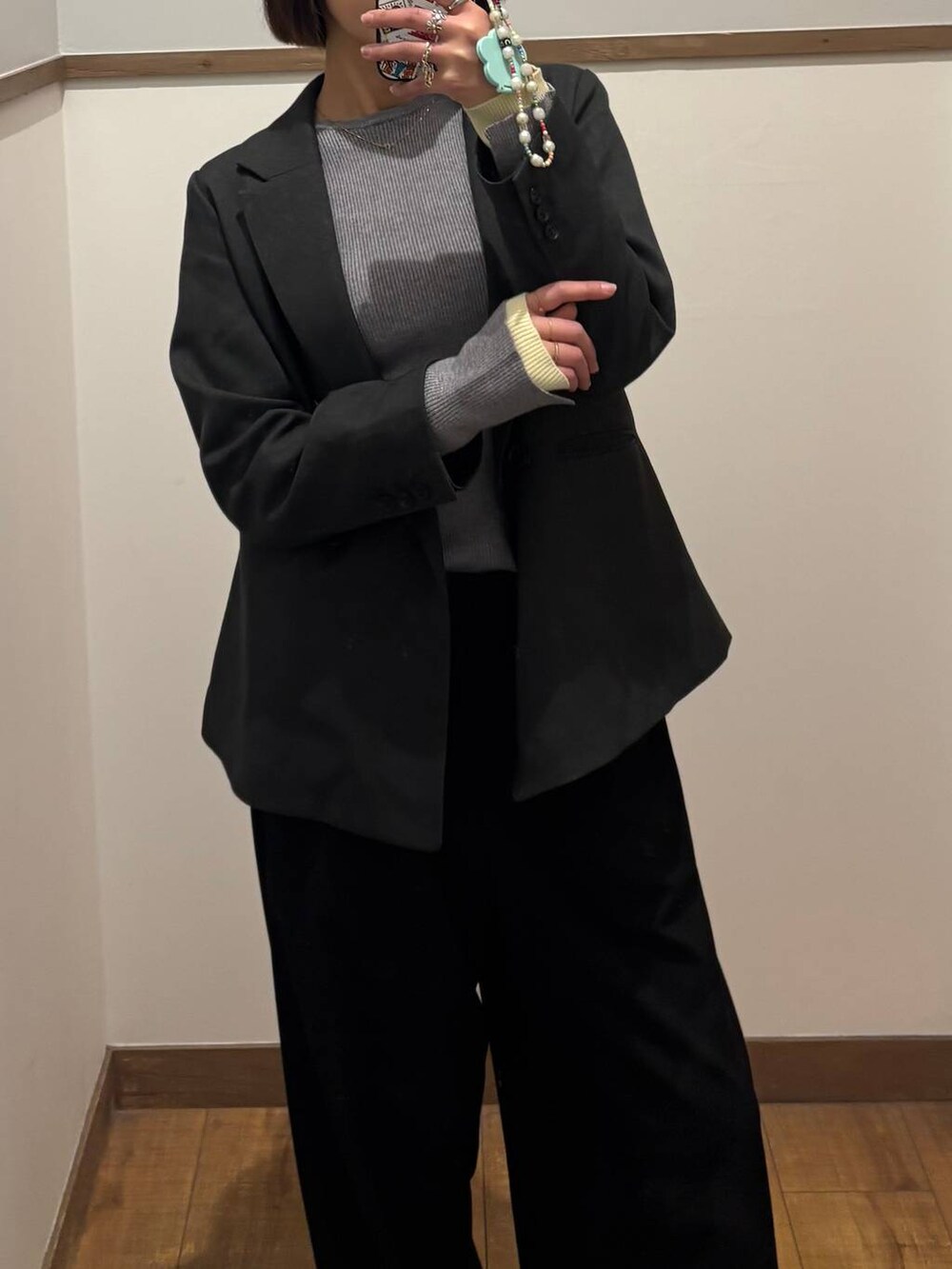 グレー系のテーラードジャケット、グレー系のニット/セーターを着用したレディースの冬コーディネートの2枚目の写真