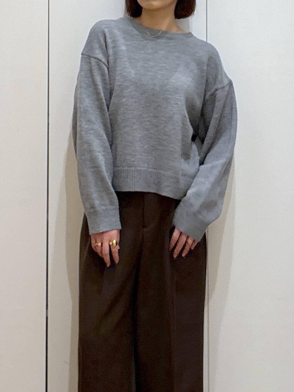 ブラック系のスニーカー、ブラウン系のその他パンツ、ゴールド系のピアス（両耳用）を着用したレディースの冬コーディネートの5枚目の写真