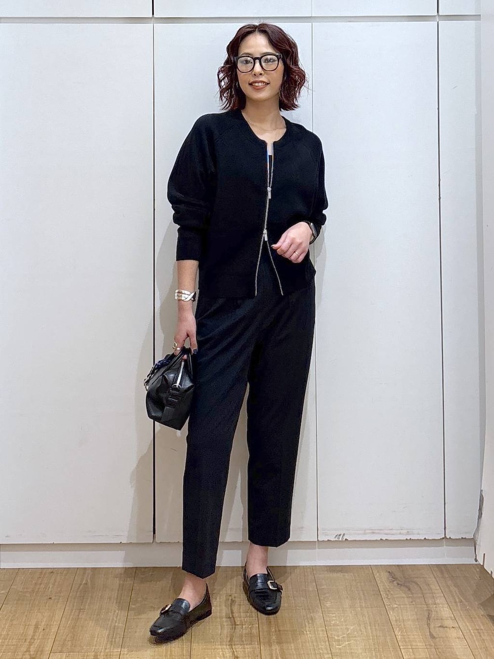 ブラック系のローファー、ブルー系のスラックス、ブラック系のカーディガン/ボレロを着用したレディースの春コーディネートの2枚目の写真