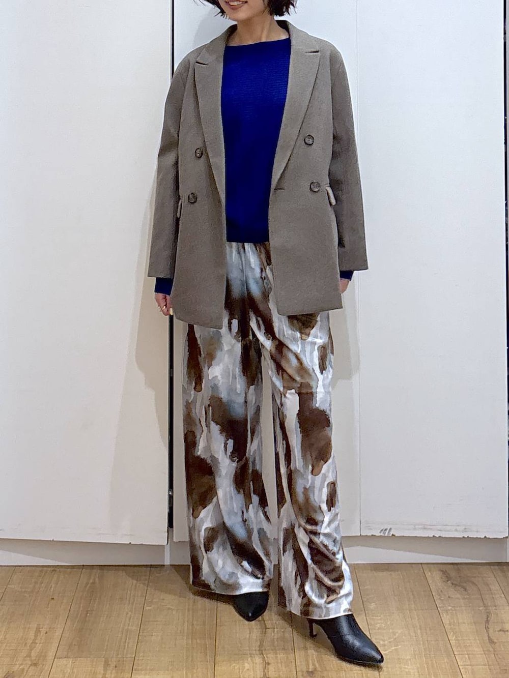 ブルー系のニット/セーター、ブラウン系のテーラードジャケット、ブラック系のブーツを着用したレディースの冬コーディネートの3枚目の写真