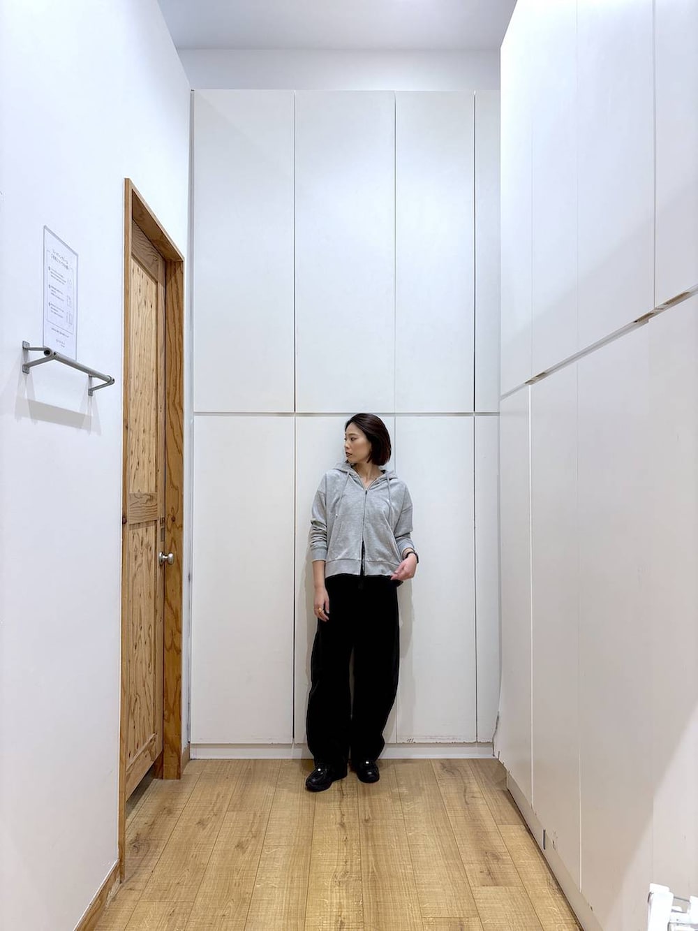 ブラック系のスニーカー、ブラック系のデニムパンツ、グレー系のパーカーを着用したレディースの冬コーディネートの7枚目の写真