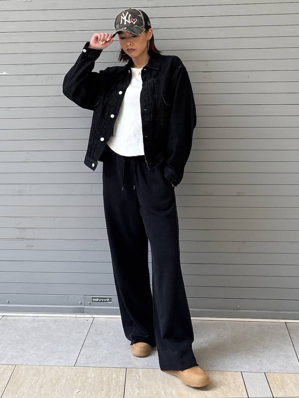 ブラック系のデニムジャケット、ブラック系のスウェットパンツ、ゴールド系のネックレスを着用したレディースの春コーディネートの2枚目の写真