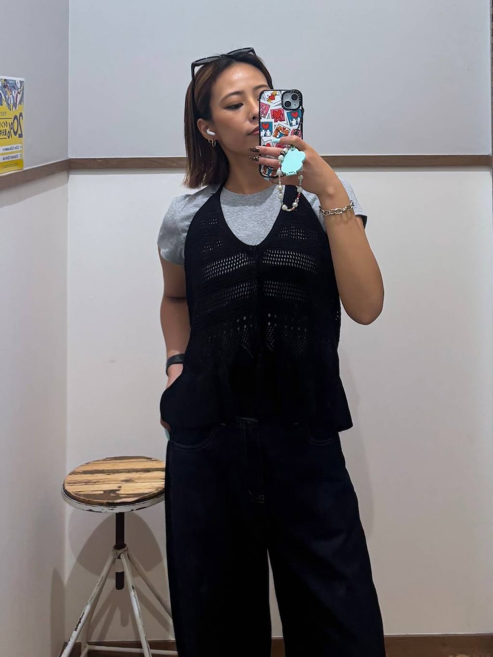ブルー系のデニムパンツ、ブラック系のサンダル、ブラック系のベストを着用したレディースの春コーディネートの3枚目の写真