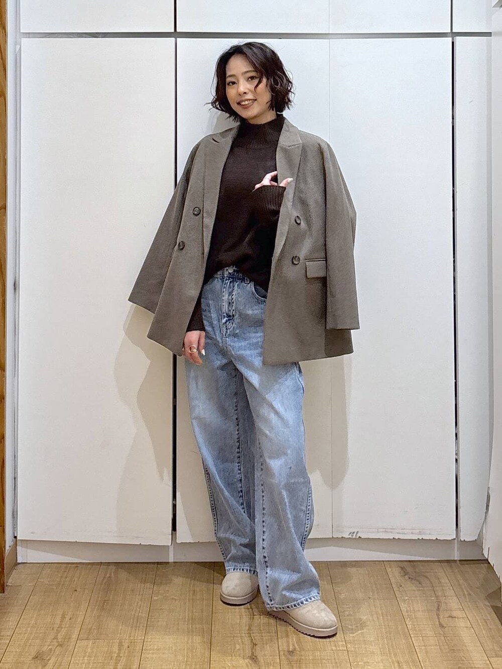 ブルー系のデニムパンツ、ブラウン系のニット/セーター、ブラウン系のテーラードジャケットを着用したレディースの冬コーディネートの3枚目の写真