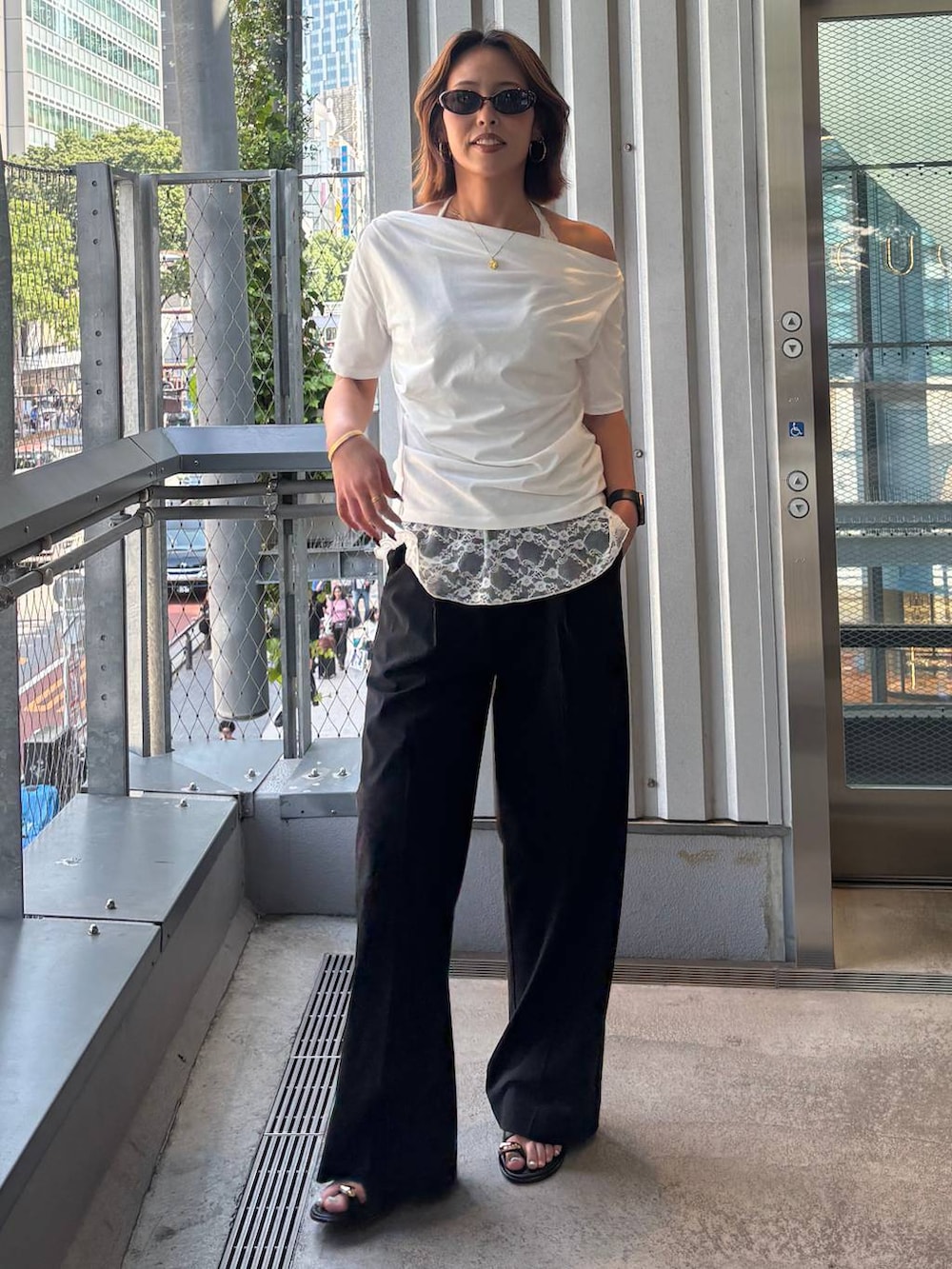 ブラック系のその他パンツ、ブラック系のサンダル、ホワイト系のTシャツ/カットソーを着用したレディースの春コーディネートの2枚目の写真