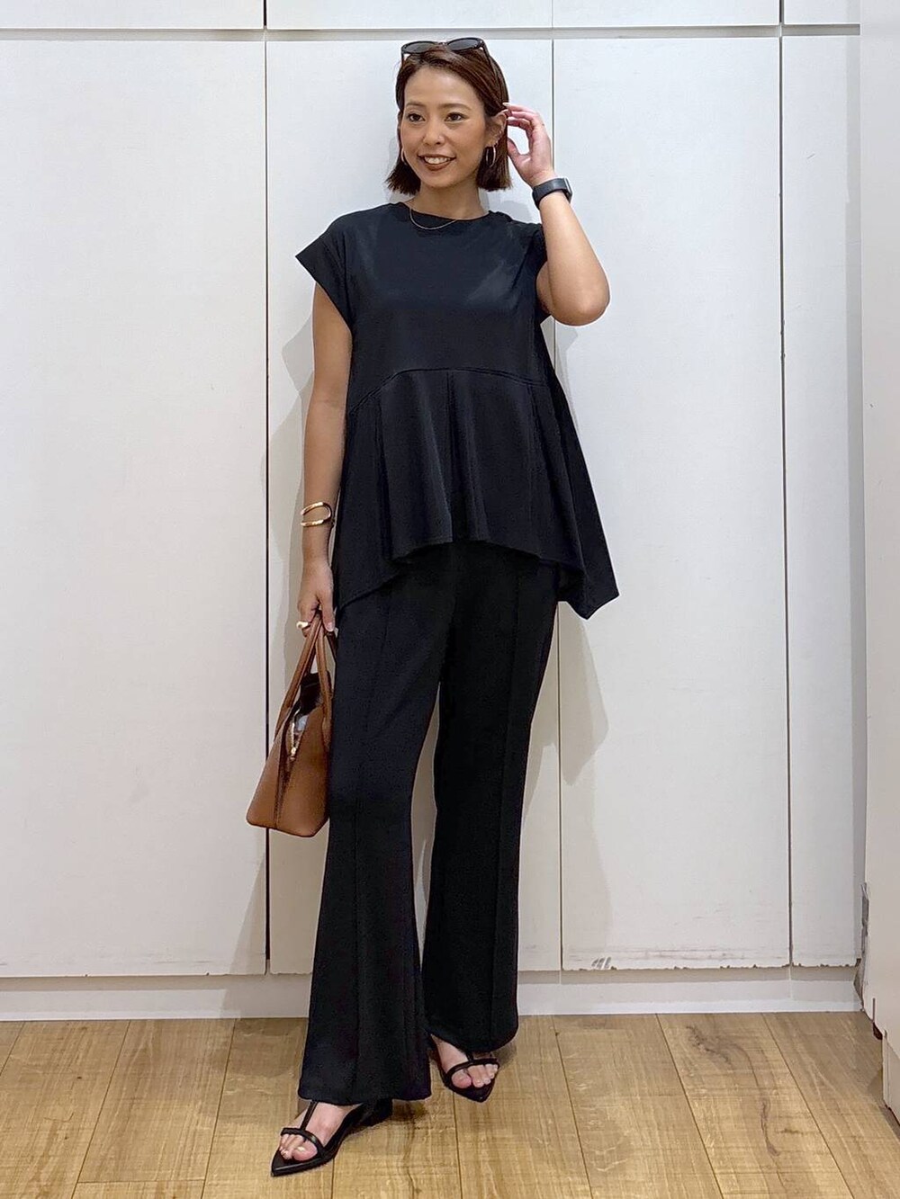 ブラウン系のショルダーバッグ、ブラック系のTシャツ/カットソー、ブラック系のその他パンツを着用したレディースの夏コーディネートの2枚目の写真