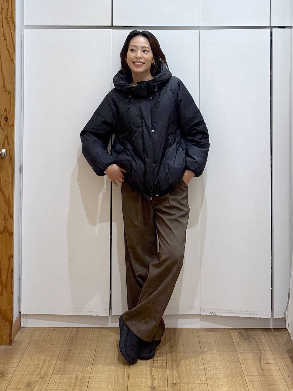 ブラック系のダウンジャケット/コート、ブラウン系のその他パンツ、ホワイト系のTシャツ/カットソーを着用したレディースの冬コーディネートの2枚目の写真