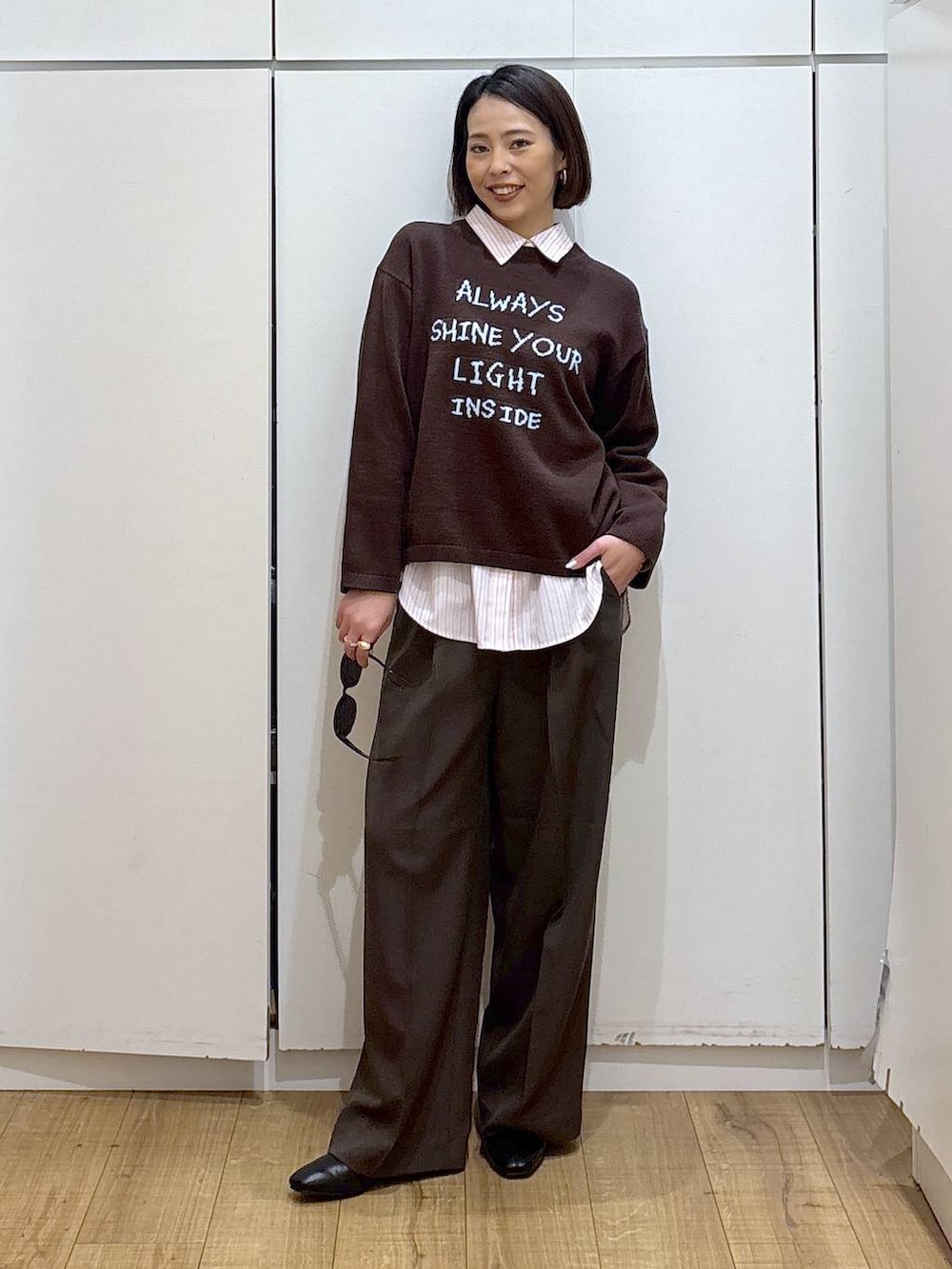 ピンク系のシャツ/ブラウス、ブラック系のブーツ、ブラウン系のニット/セーターを着用したレディースの冬コーディネートの3枚目の写真