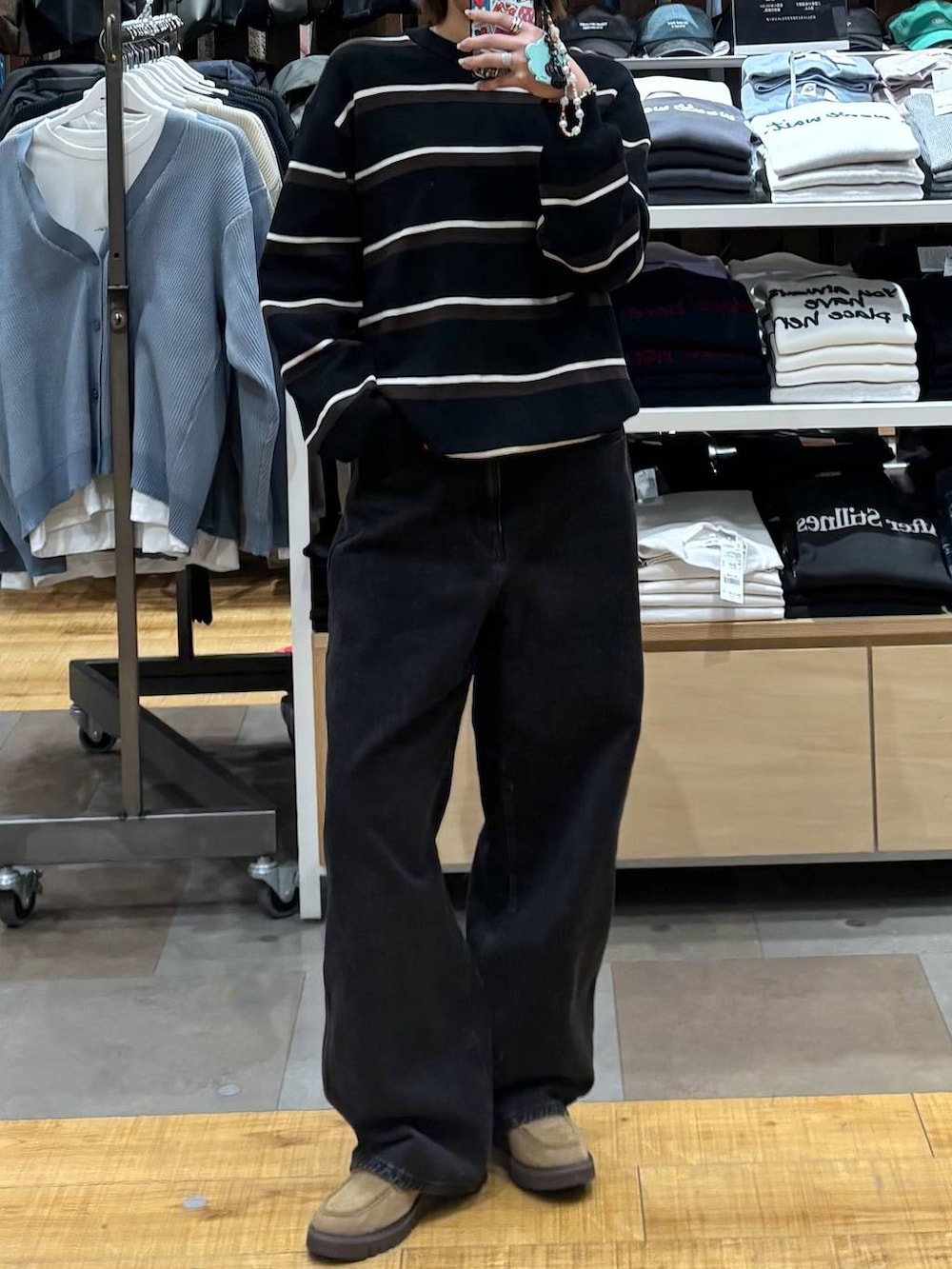 ブラック系のデニムパンツ、ベージュ系のローファーを着用したレディースの冬コーディネートの2枚目の写真