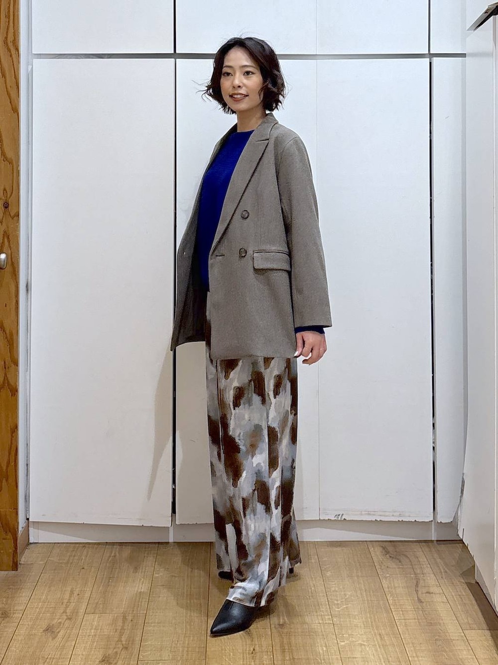 ブルー系のニット/セーター、ブラウン系のテーラードジャケット、ブラック系のブーツを着用したレディースの冬コーディネートの4枚目の写真