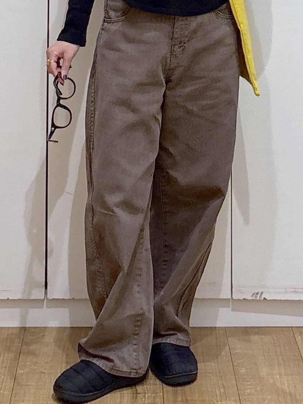 ブラウン系のデニムパンツ、イエロー系のトートバッグ、ブラック系のTシャツ/カットソーを着用したレディースの冬コーディネートの4枚目の写真