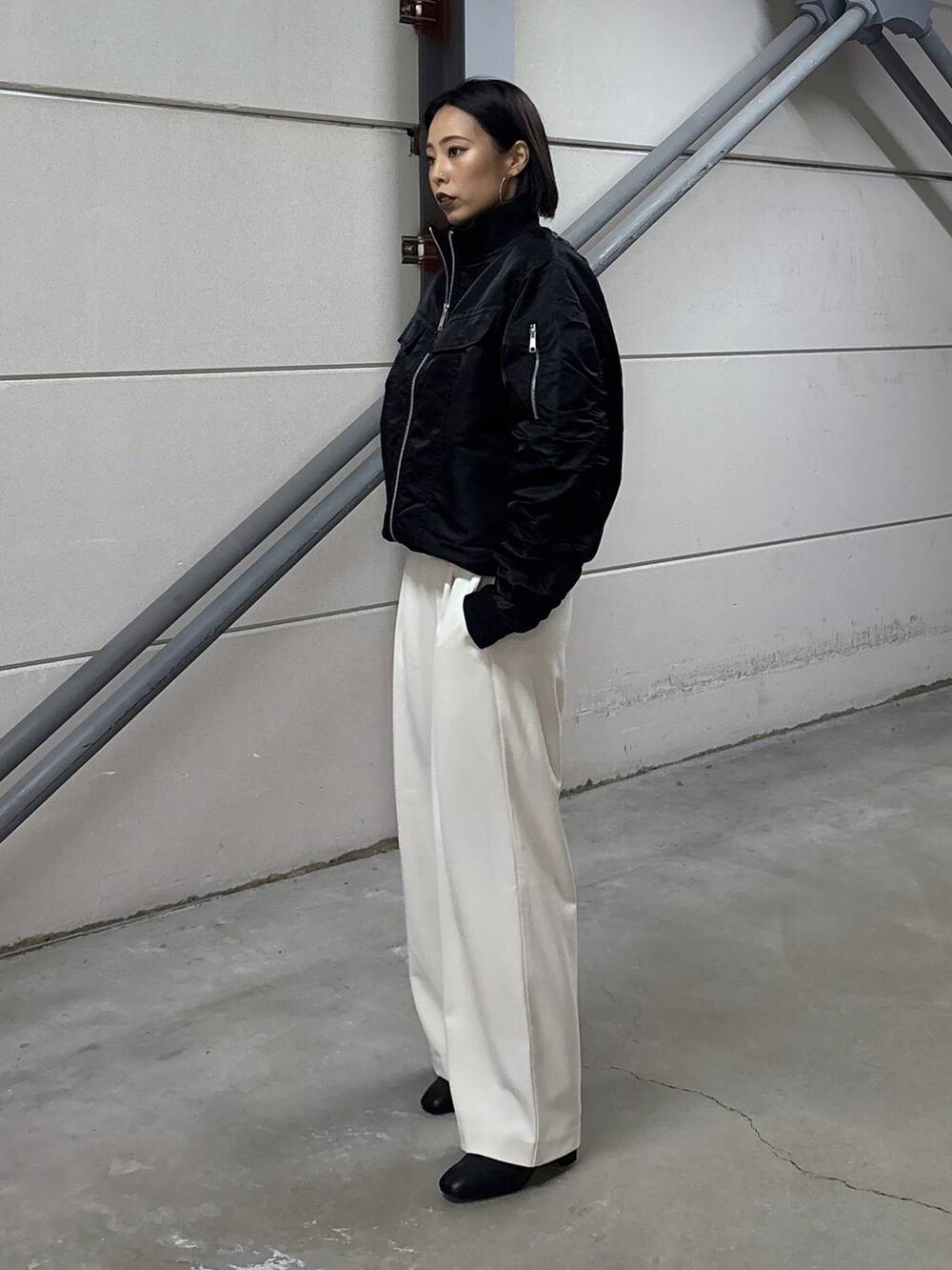 ブラック系のニット/セーター、グレー系のその他パンツ、ブラック系のブーツを着用したレディースの秋コーディネートの5枚目の写真