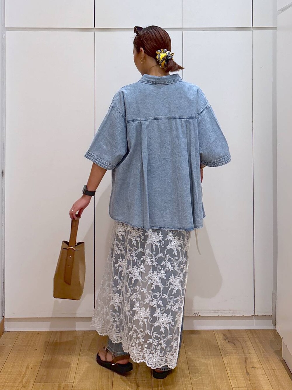 ブルー系のデニムパンツ、ブラウン系のショルダーバッグ、ブルー系のシャツ/ブラウスを着用したレディースの夏コーディネートの4枚目の写真