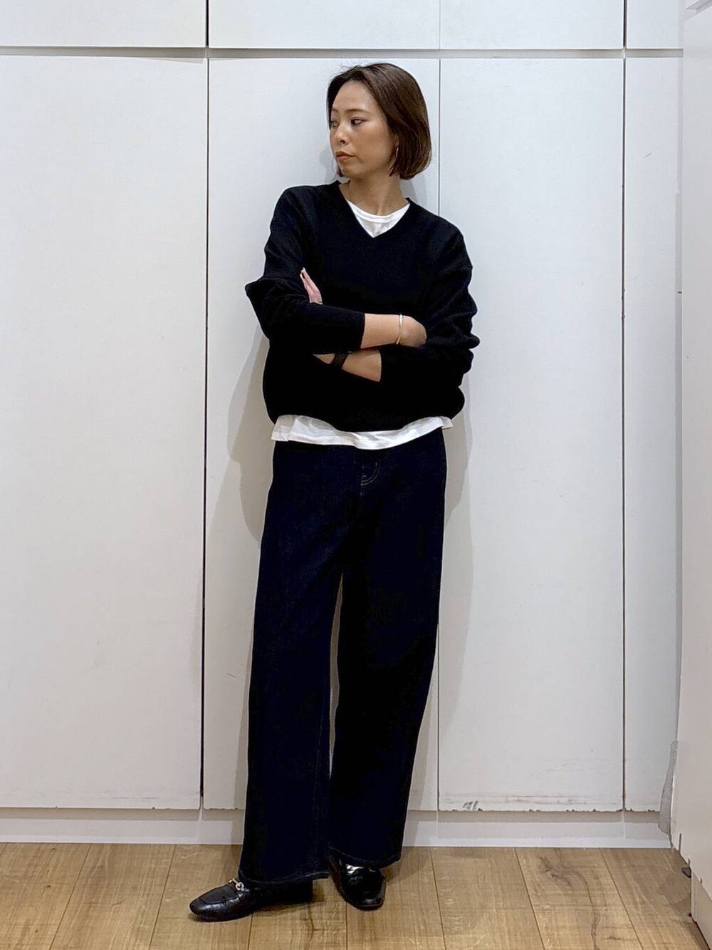 ブラック系のローファー、ブルー系のデニムパンツ、ブラック系のスウェットを着用したレディースの秋コーディネートの2枚目の写真