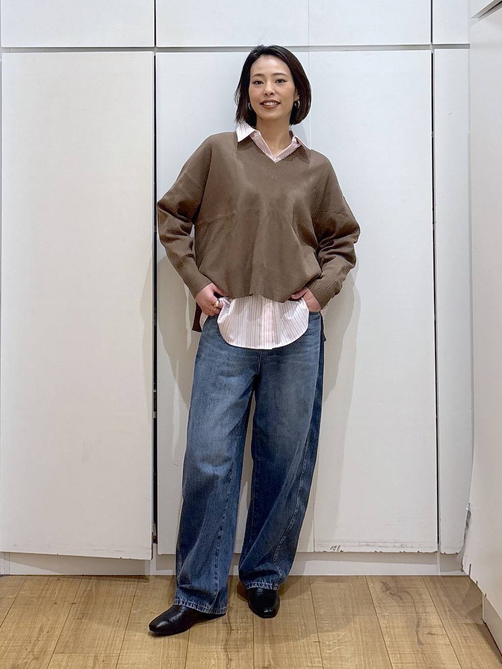 ピンク系のシャツ/ブラウス、ブラック系のブーツ、ブルー系のデニムパンツを着用したレディースの冬コーディネートの2枚目の写真