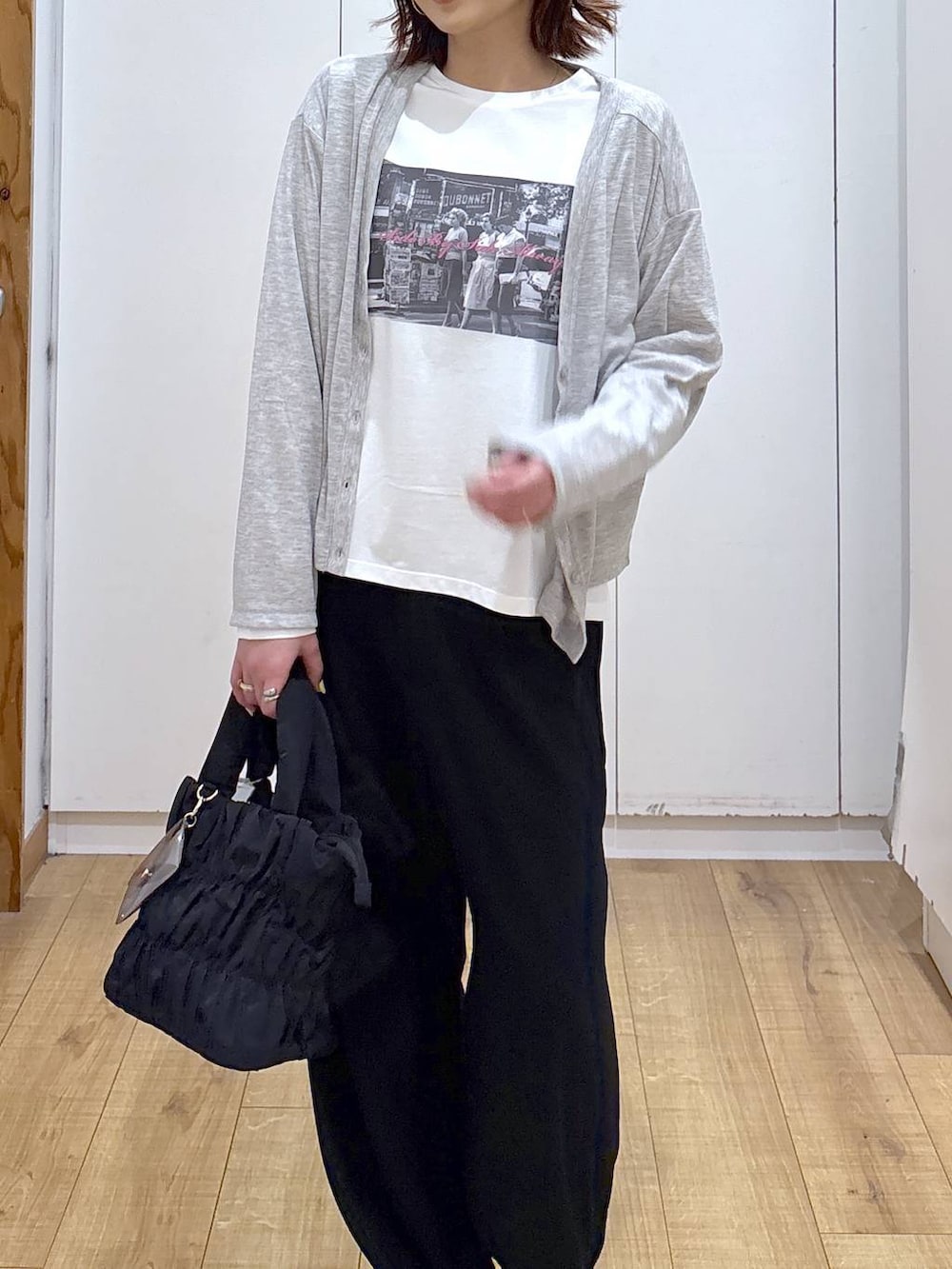 ブラック系のトートバッグ、ブラック系のその他パンツ、ホワイト系のTシャツ/カットソーを着用したレディースの春コーディネートの4枚目の写真