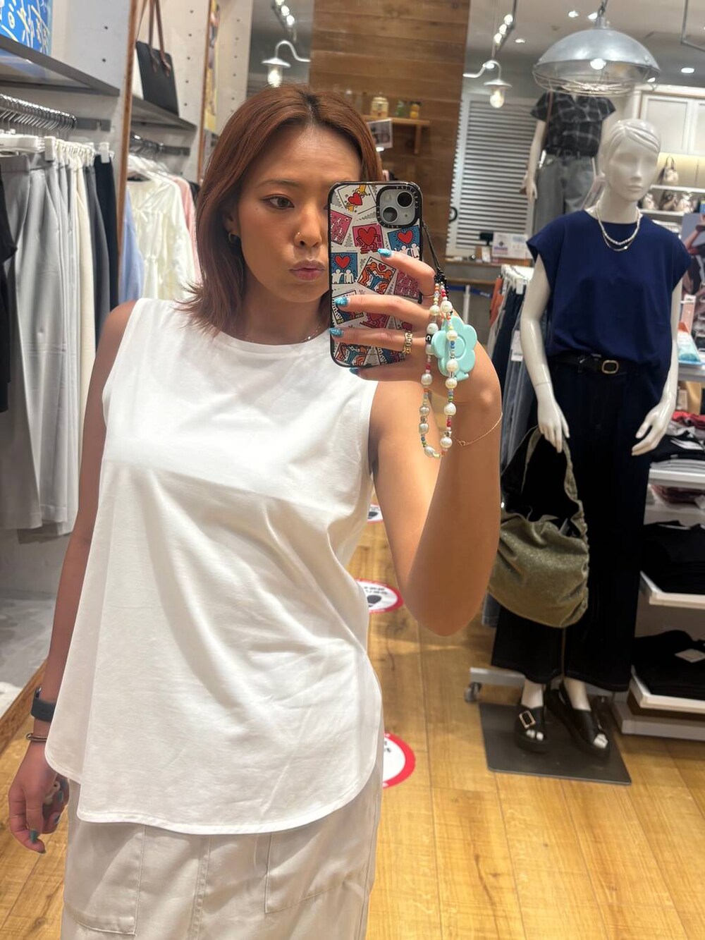 グレー系のスカート、ホワイト系のTシャツ/カットソー、ベージュ系のサンダルを着用したレディースの夏コーディネートの2枚目の写真