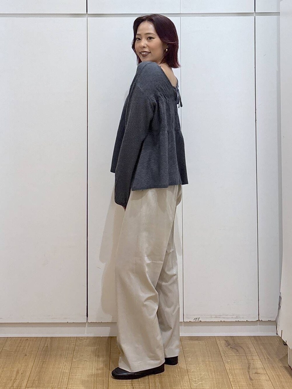 ブラック系のローファー、ベージュ系のスラックス、グレー系のカーディガン/ボレロを着用したレディースの春コーディネートの3枚目の写真