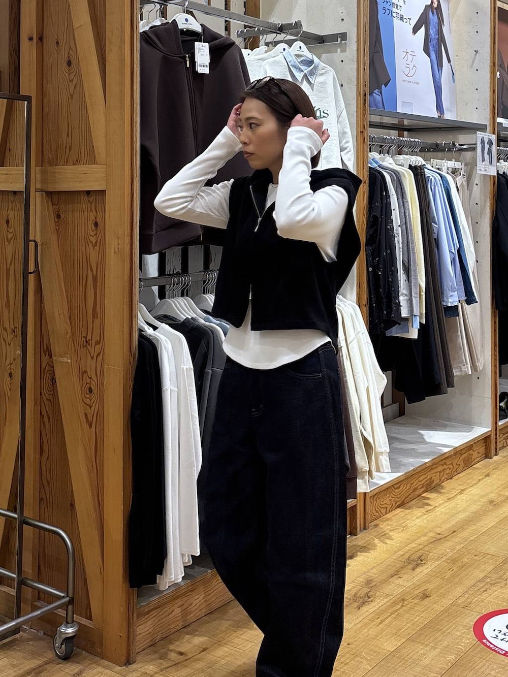 ブルー系のデニムパンツ、ブラック系のベストを着用したレディースの冬コーディネートの3枚目の写真