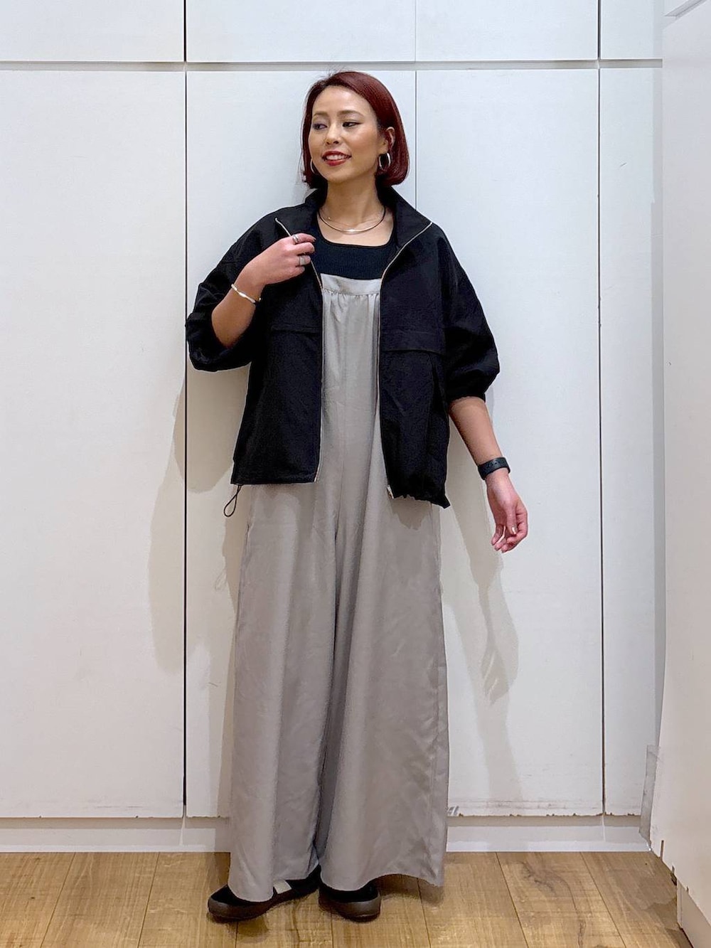 ブラック系のスニーカー、ブラック系のブルゾン、ブラック系のタンクトップを着用したレディースの春コーディネートの2枚目の写真