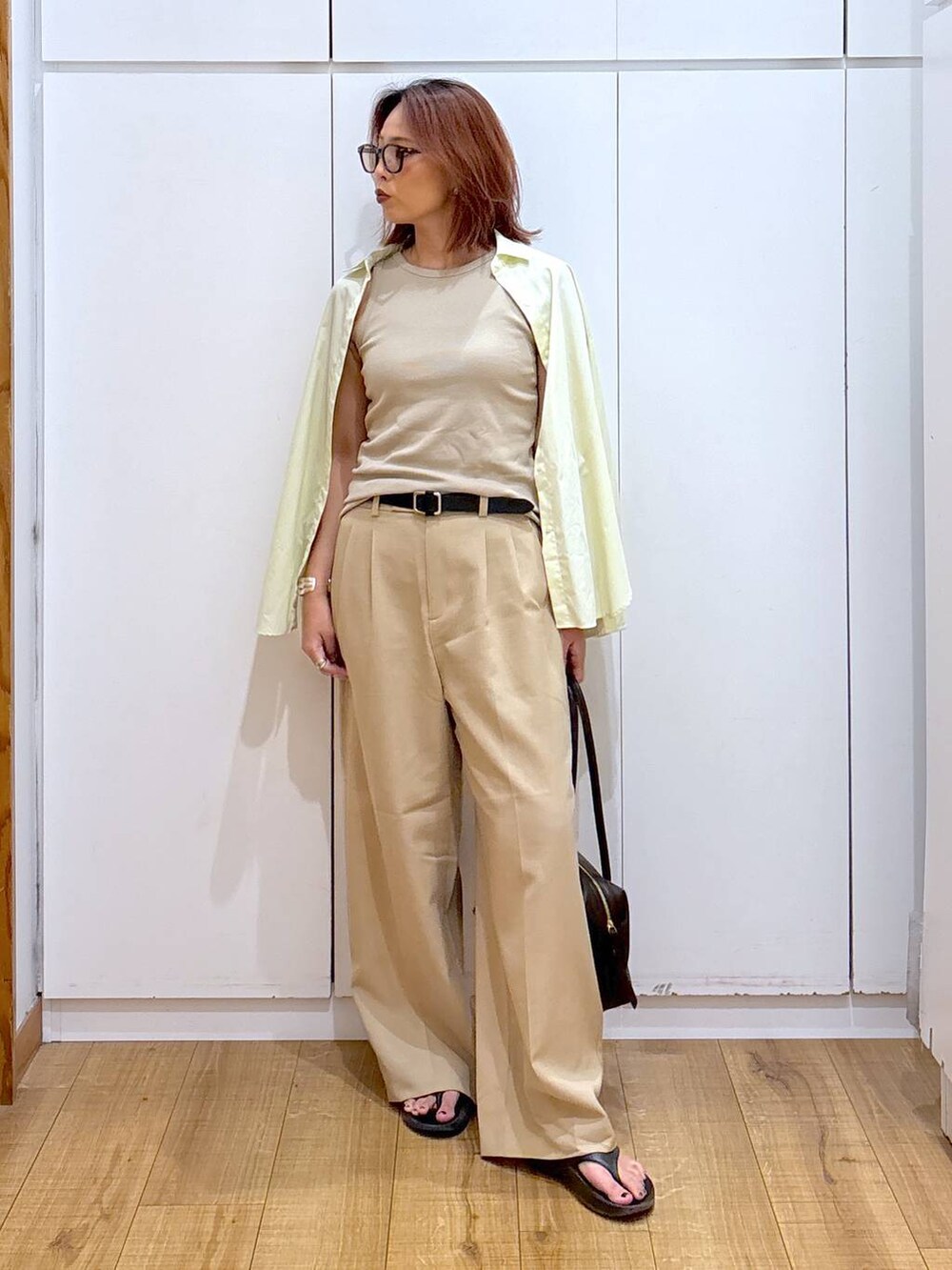 ベージュ系のその他パンツ、ベージュ系のタンクトップ、ブラウン系のボストンバッグを着用したレディースの夏コーディネートの2枚目の写真