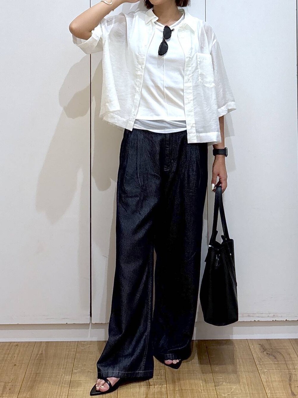 ブラック系のハンドバッグ、ホワイト系のシャツ/ブラウス、ホワイト系のTシャツ/カットソーを着用したレディースの夏コーディネートの2枚目の写真