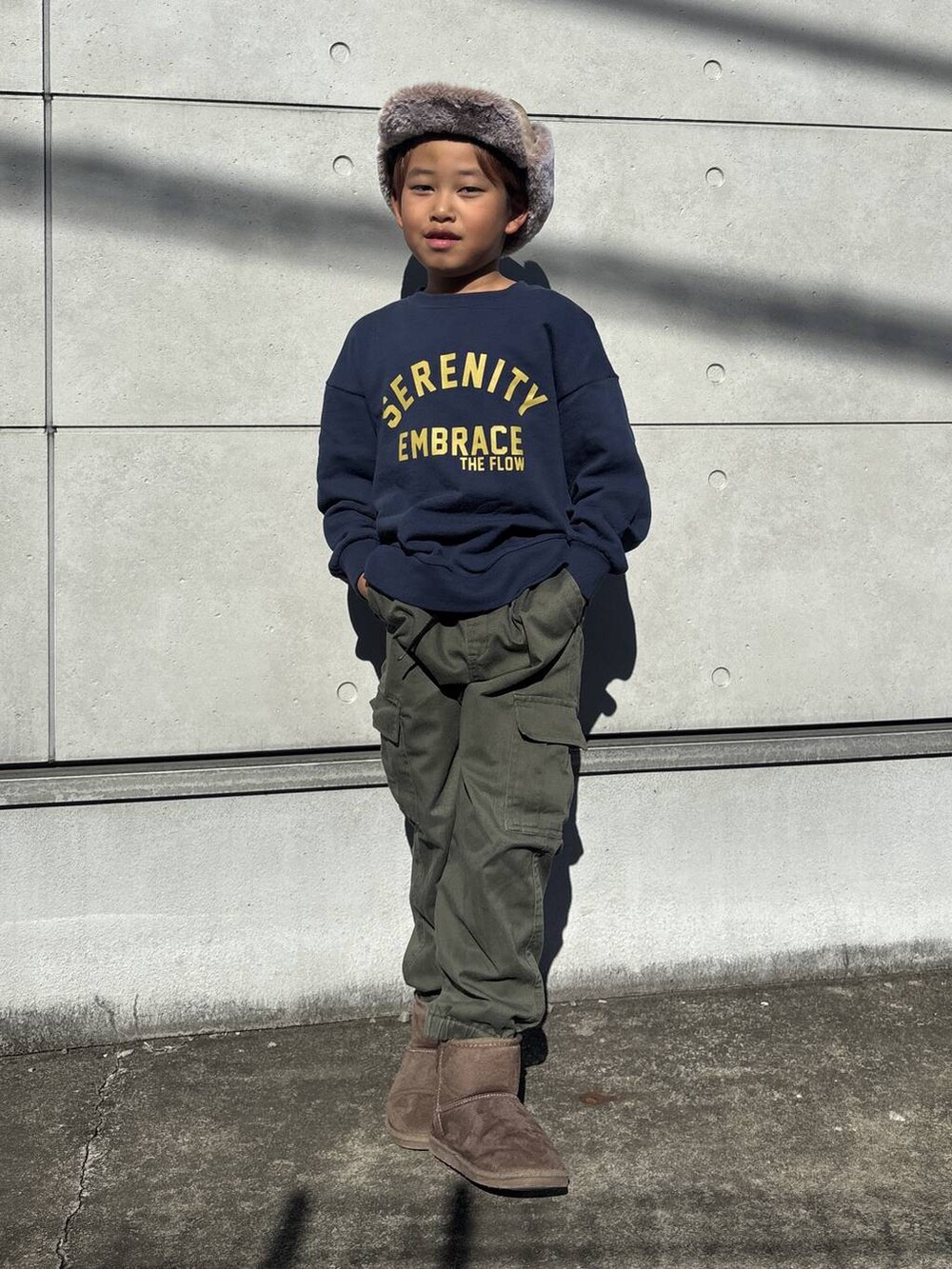 ブルー系のスウェット、グリーン系のカーゴパンツ、ブラウン系のブーツを着用したキッズの秋コーディネートの5枚目の写真