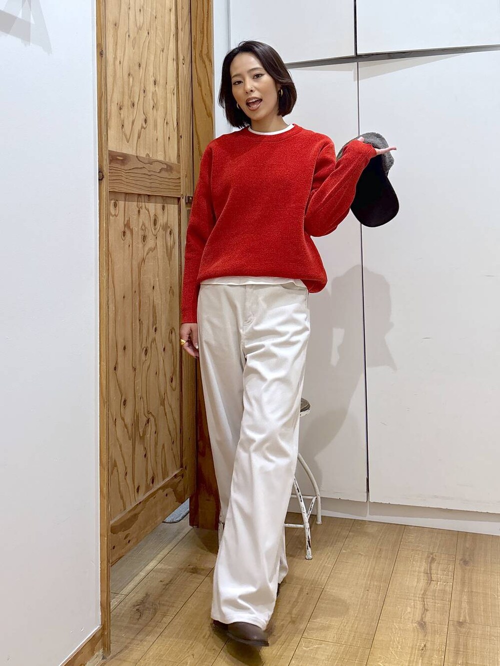 グレー系のその他パンツ、ブラウン系のブーツ、レッド系のニット/セーターを着用したレディースの冬コーディネートの2枚目の写真