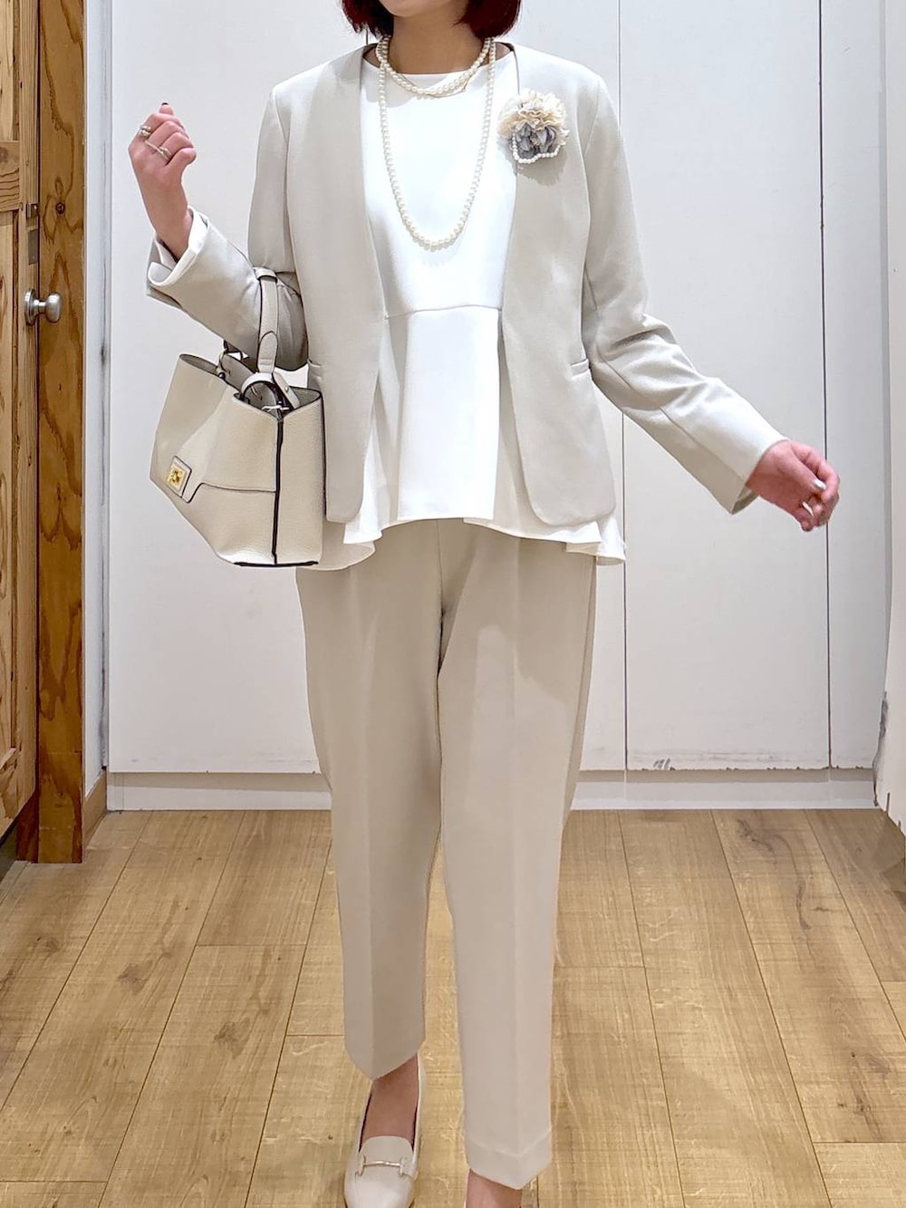 ベージュ系のセットアップ、ベージュ系のショルダーバッグ、ホワイト系のローファーを着用したレディースの春コーディネートの5枚目の写真