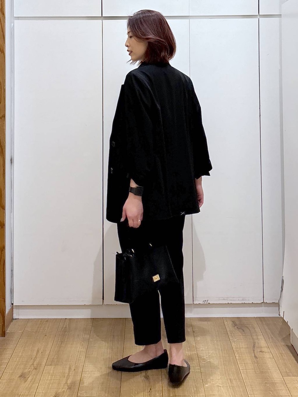 ブラック系のパンプス、ブラック系のスラックス、ブラック系のテーラードジャケットを着用したレディースの春コーディネートの5枚目の写真