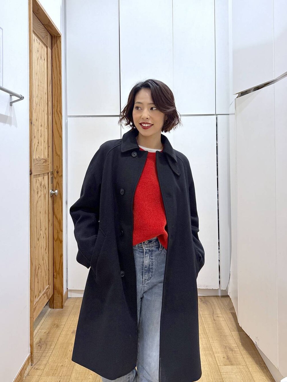 ブラック系のローファー、ブラック系のステンカラーコート、ブルー系のデニムパンツを着用したレディースの冬コーディネートの9枚目の写真