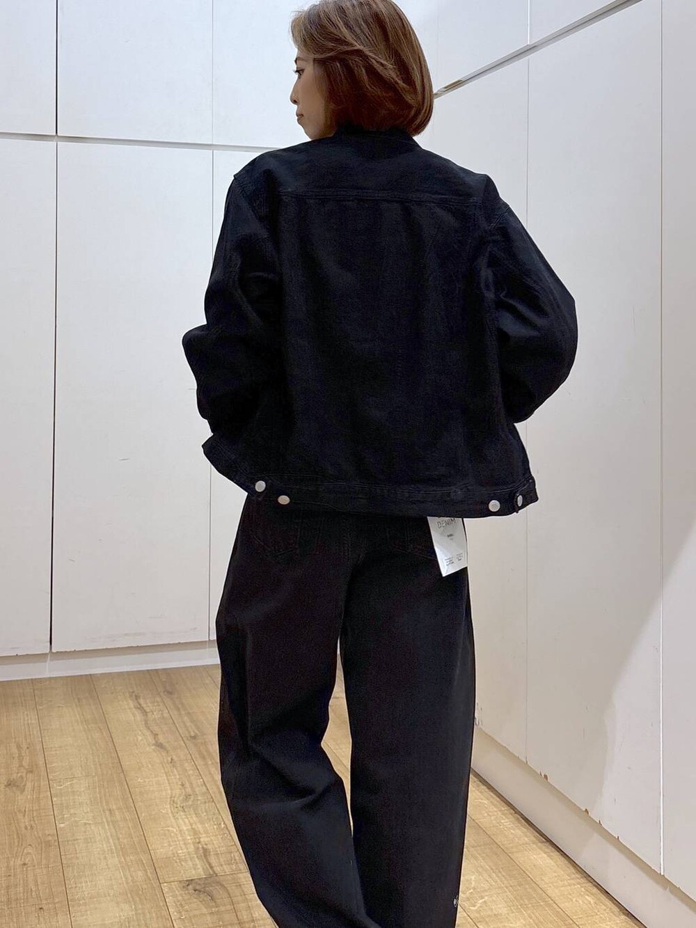 ブラック系のデニムパンツ、ブラック系のデニムジャケット、ホワイト系のキャミソールを着用したレディースの春コーディネートの6枚目の写真