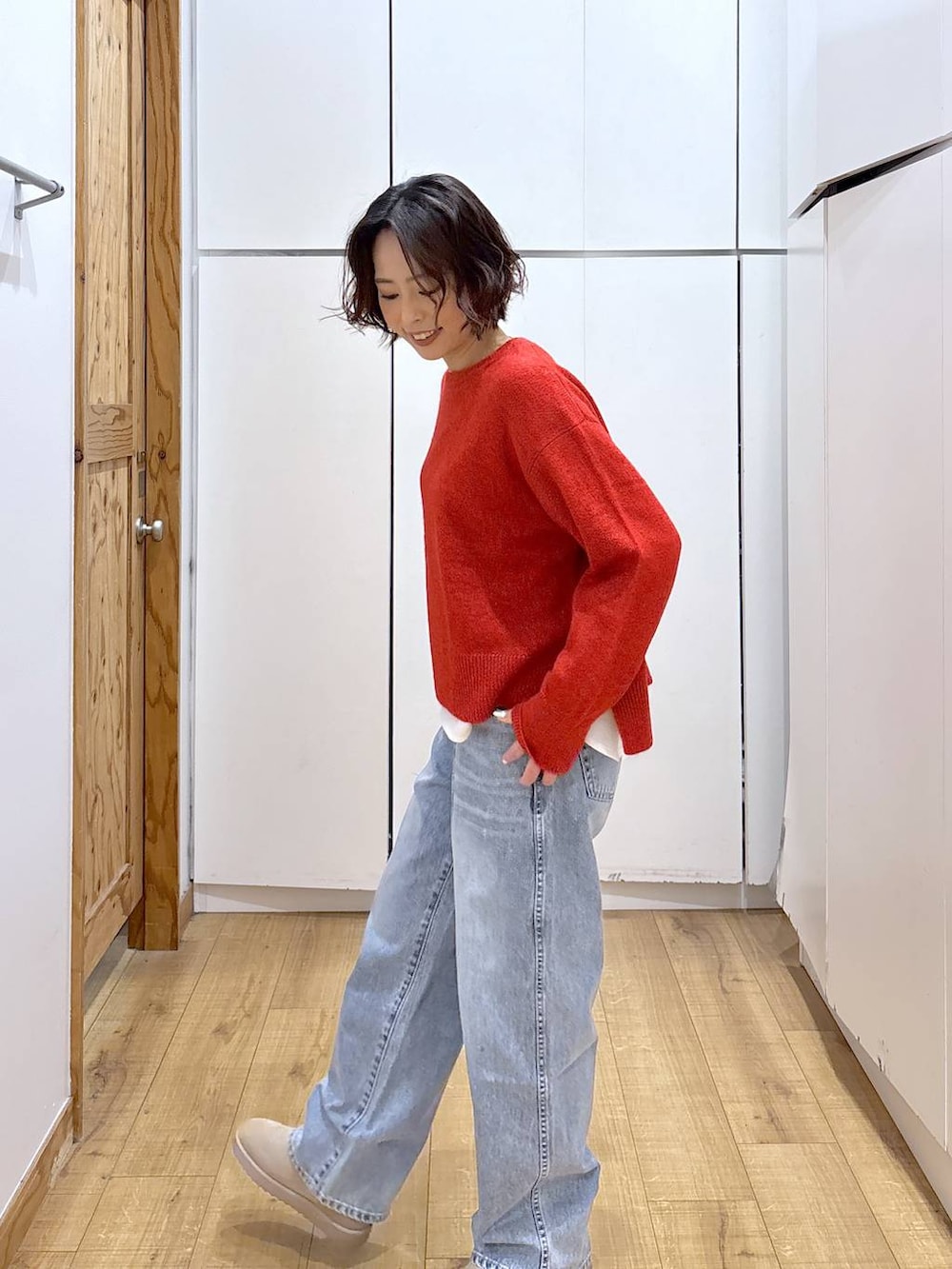 ブルー系のデニムパンツ、レッド系のニット/セーター、ホワイト系のTシャツ/カットソーを着用したレディースの冬コーディネートの6枚目の写真